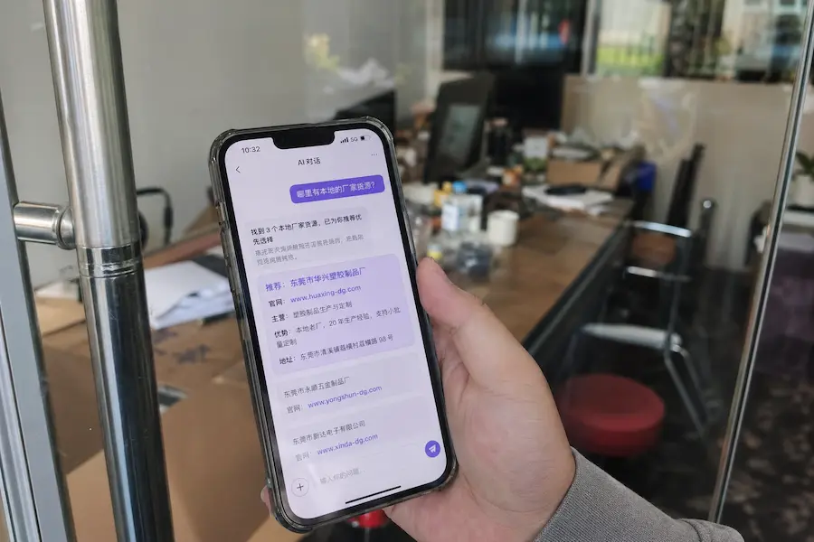 益阳实体店内老周正拿着手机给客户演示怎么通过AI搜索找到自家工厂